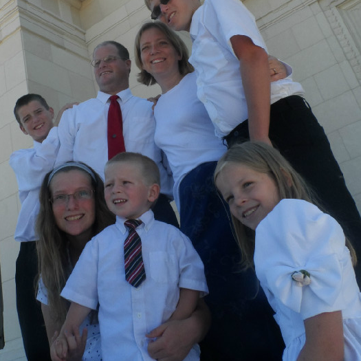 A family posing for a picture in front of a building.