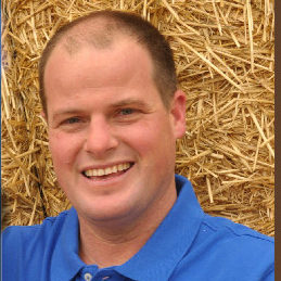 A man in blue shirt smiling for the camera.